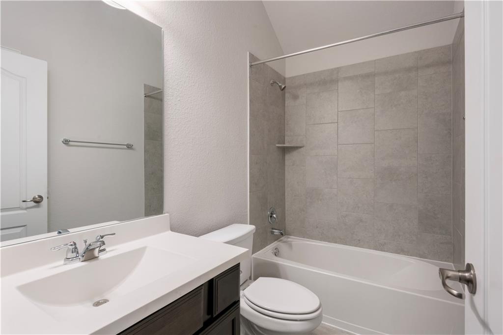 6752 Catania Loop Round Rock, TX 78665 - Photo 5 of 25 Full bathroom with a textured wall, shower combination, and vanity