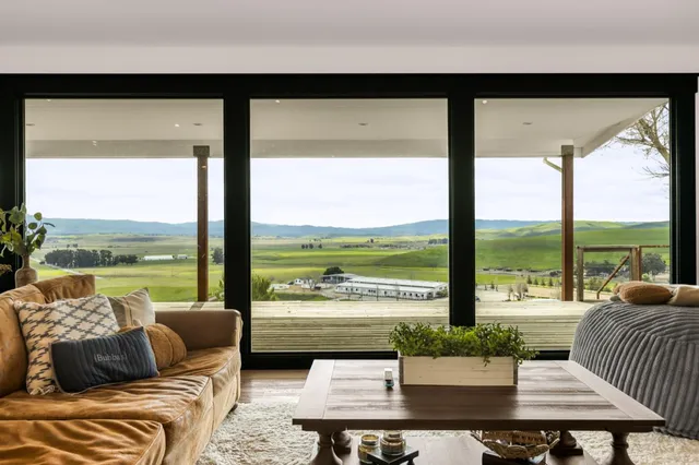 a living room with furniture and floor to ceiling windows