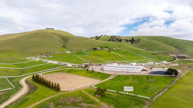 a view of a livingroom with furniture large windows wooden floor and a chandelier