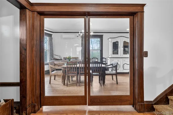 a dining room with furniture and a floor to ceiling window