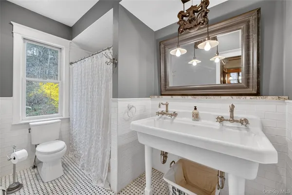 a bathroom with a sink a toilet and a mirror