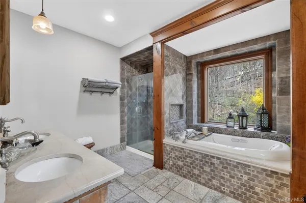 a spacious bathroom with a tub sink and mirror