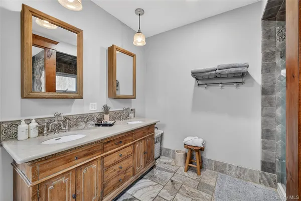 a bathroom with a sink a toilet a mirror and shower