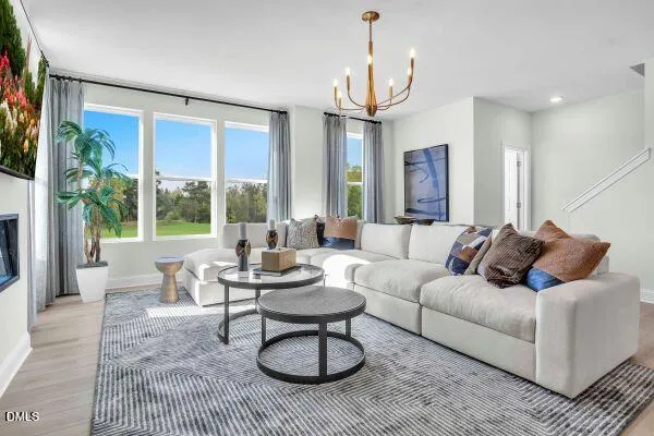 a living room with furniture a large window and a chandelier