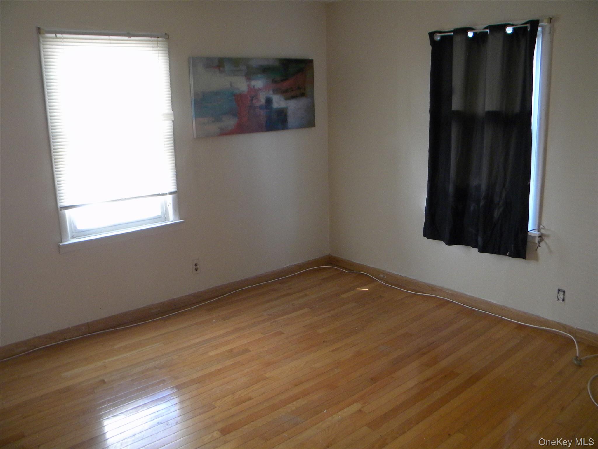 241-26 86th Road Queens, NY 11426 - Photo 17 of 38 an empty room with wooden floor and closet