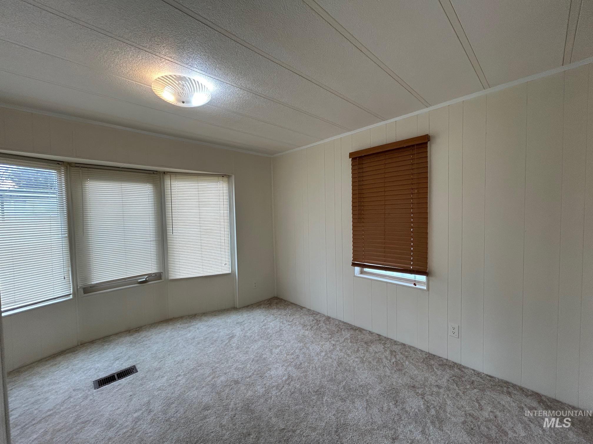 2015 6th Avenue, Unit 131A Clarkston, WA 99403 - Photo 18 of 26 Carpeted spare room with wood walls