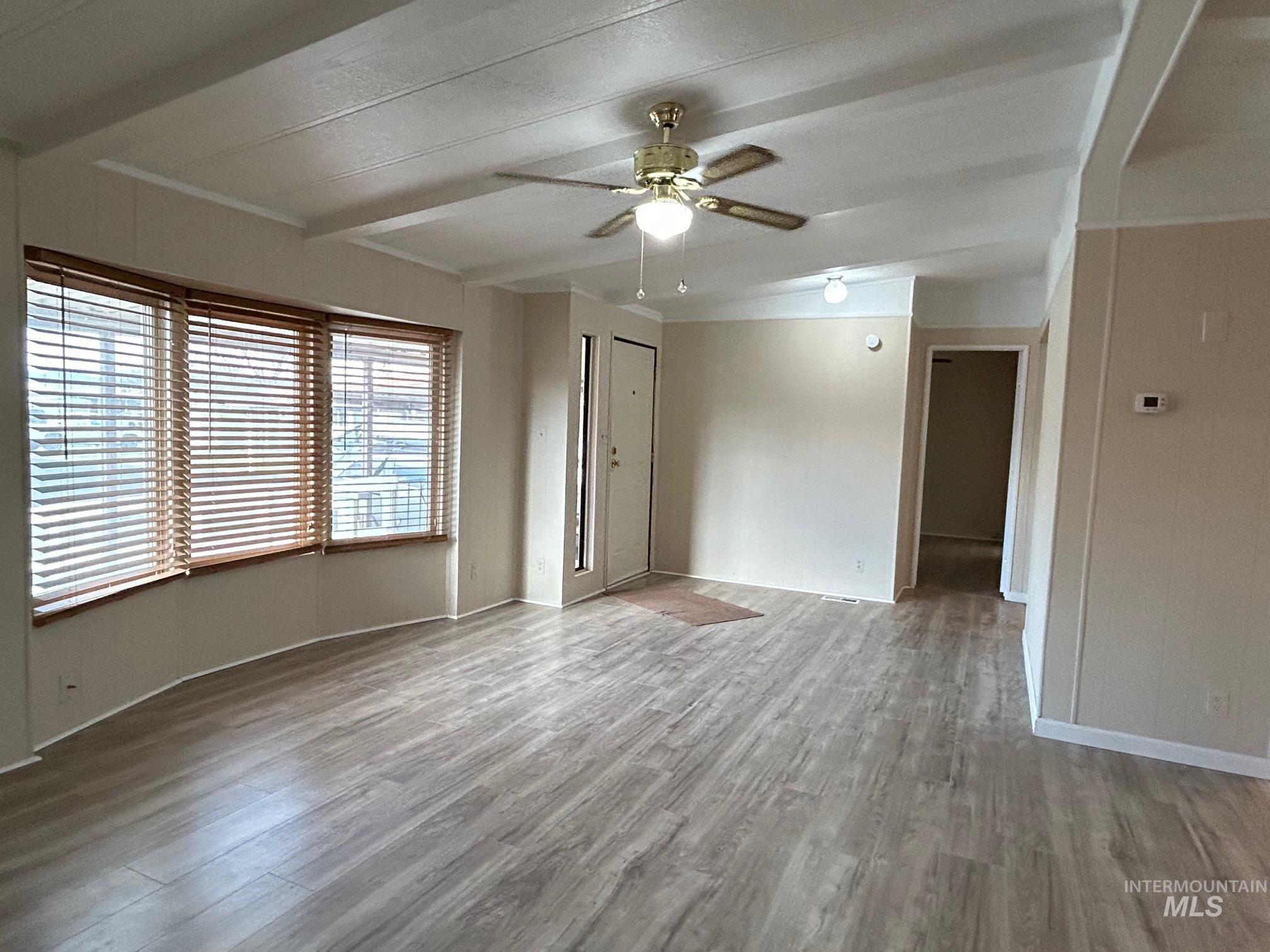 2015 6th Avenue, Unit 131A Clarkston, WA 99403 - Photo 2 of 26 Unfurnished room with wood finished floors, a ceiling fan, and beamed ceiling