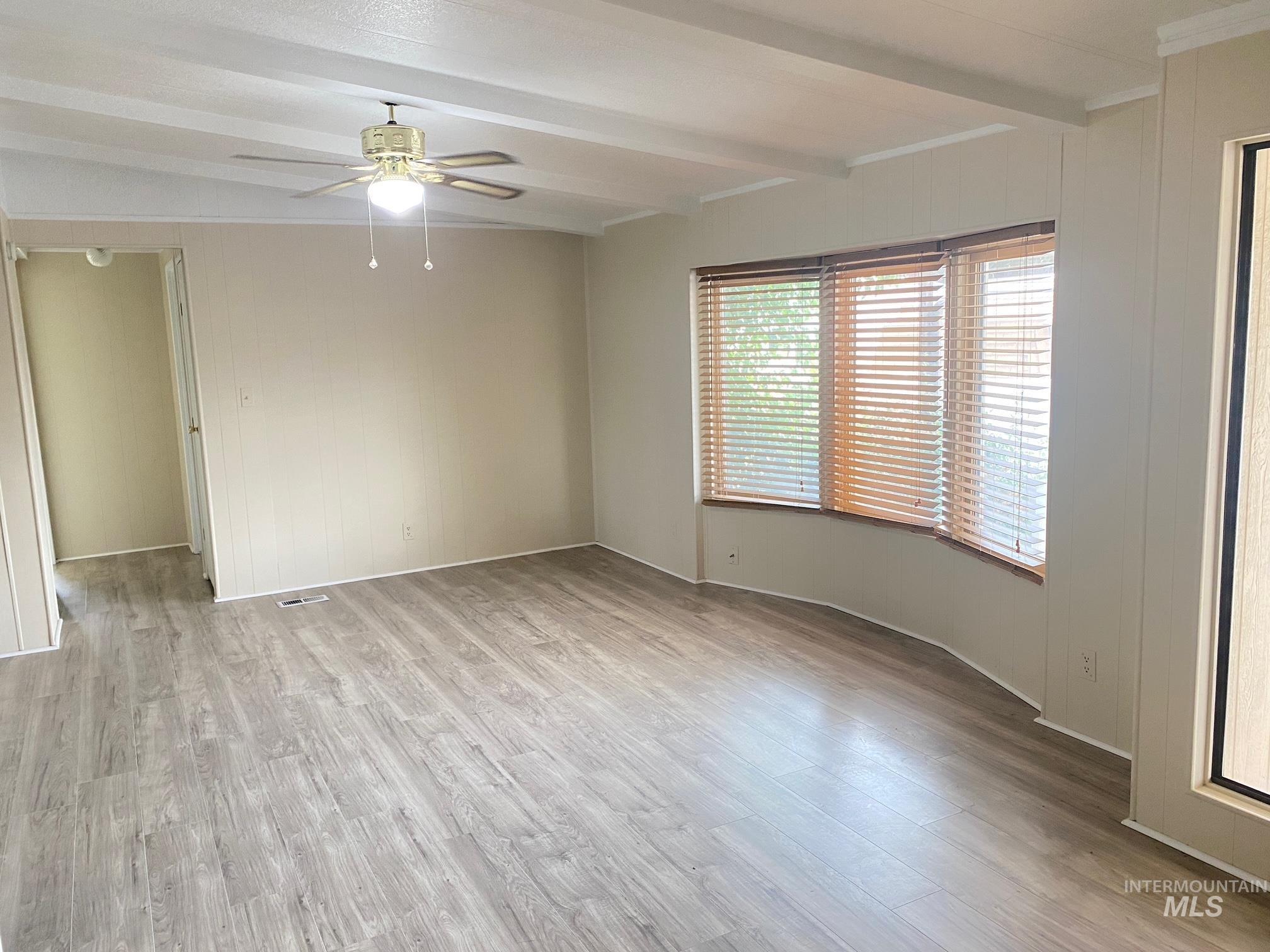 2015 6th Avenue, Unit 131A Clarkston, WA 99403 - Photo 2 of 13 Living room with light wood-type flooring, wood walls, and a ceiling fan