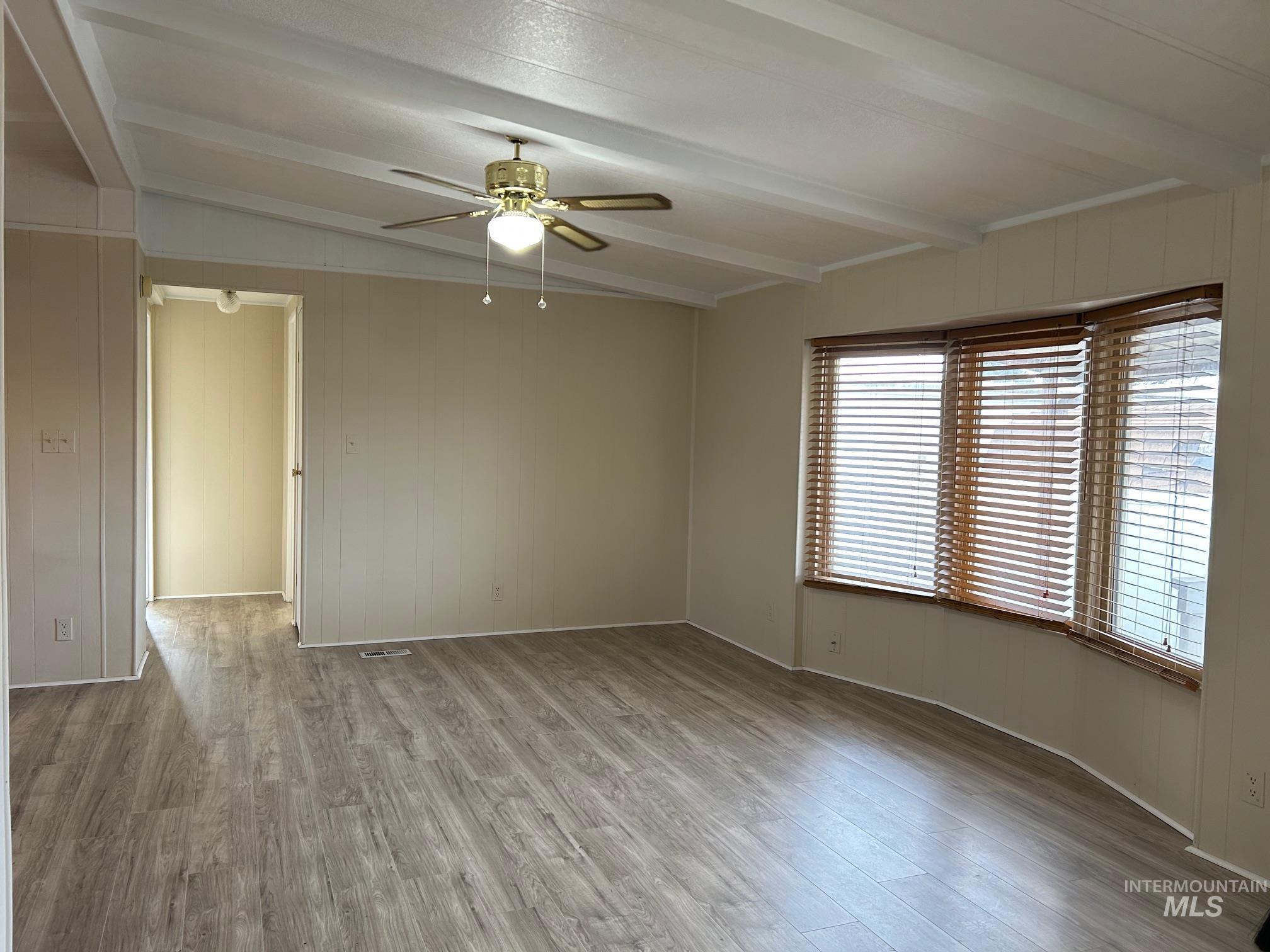 2015 6th Avenue, Unit 131A Clarkston, WA 99403 - Photo 3 of 26 Spare room with light wood-style floors, wood walls, and a ceiling fan