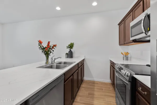 a kitchen with stainless steel appliances granite countertop a sink a stove and cabinets