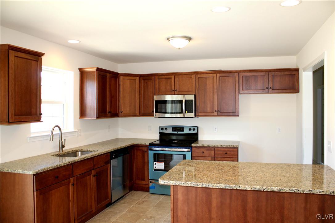 437 English Road Bath, PA 18014 - Photo 4 of 11 a kitchen with stainless steel appliances granite countertop a sink stove microwave and refrigerator