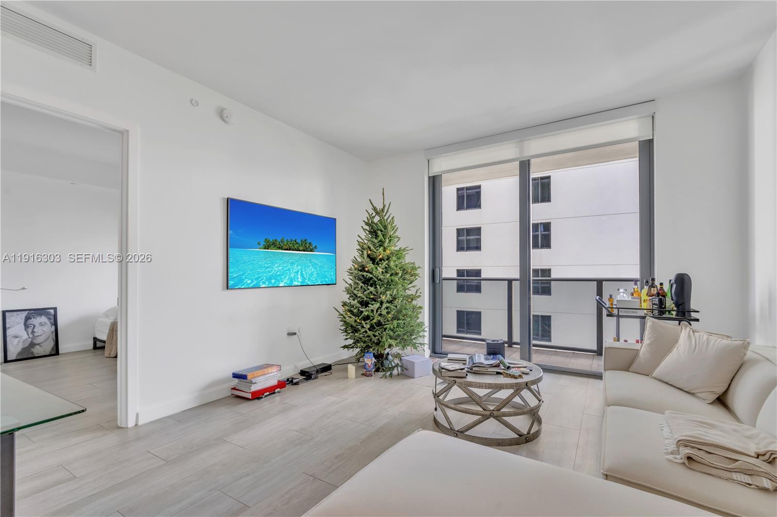 55 Southwest 9th Street, Unit 2610 Miami, FL 33130 - Photo 5 of 21 a living room with furniture and a floor to ceiling window