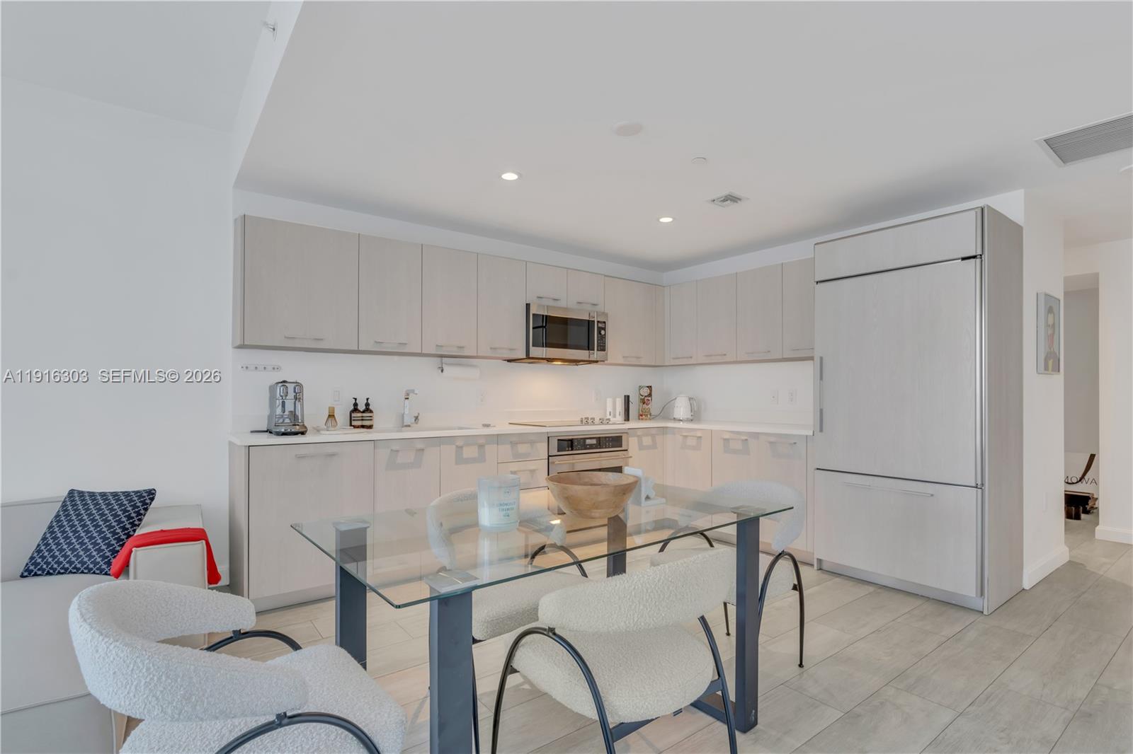 55 Southwest 9th Street, Unit 2610 Miami, FL 33130 - Photo 7 of 21 a kitchen with stainless steel appliances a refrigerator a stove a sink and white cabinets