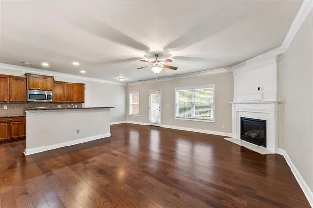 a view of an empty room with a kitchen and a fireplace
