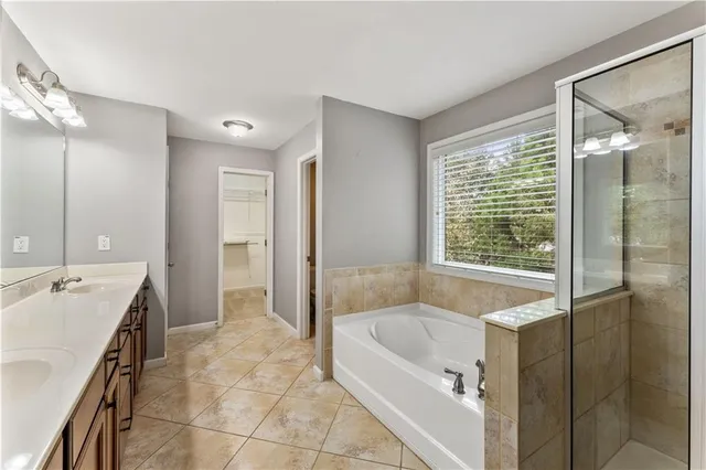 a spacious bathroom with a tub sink and mirror