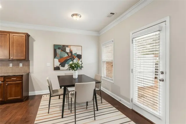 a dining room with furniture a rug a fireplace and wooden floor