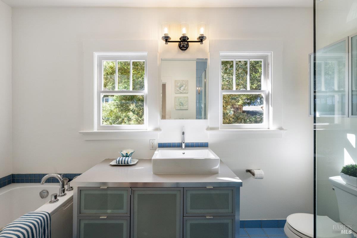 338 Paloma Avenue San Rafael, CA 94901 - Photo 17 of 31 a bathroom with a granite countertop sink a toilet a mirror and a window