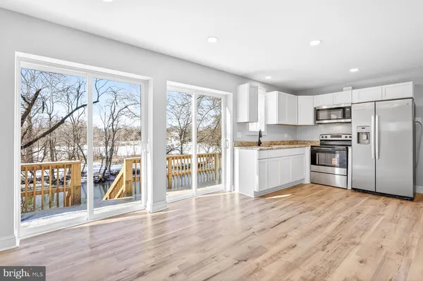 a kitchen with stainless steel appliances wooden floors and wooden cabinets