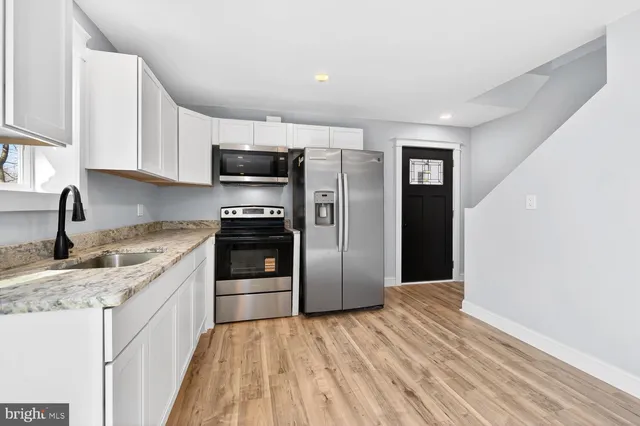 a kitchen with granite countertop a refrigerator and a sink