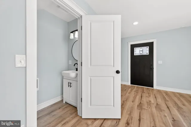 a view of a hallway with closet and wooden floor