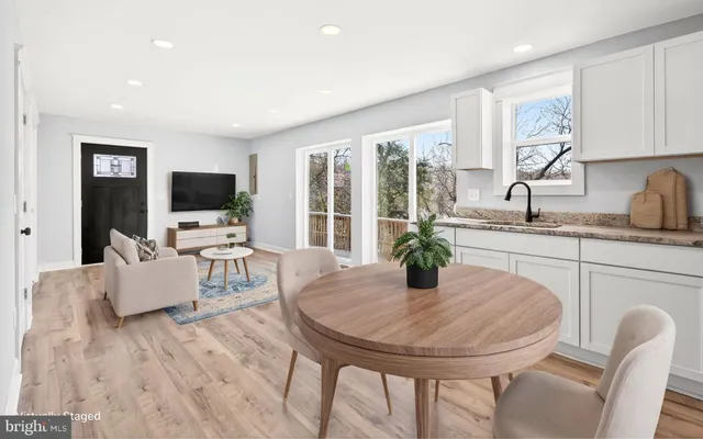 a kitchen with a table chairs and flat screen tv
