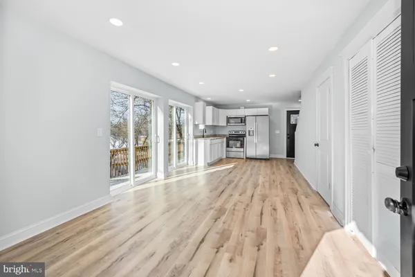 a view of empty room with wooden floor and windows