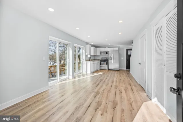 a view of empty room with wooden floor and windows