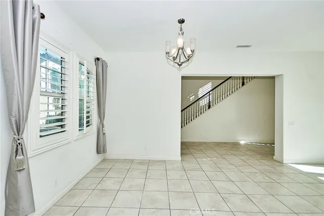 a kitchen with stainless steel appliances kitchen island granite countertop a refrigerator a stove top oven and a sink with granite countertops