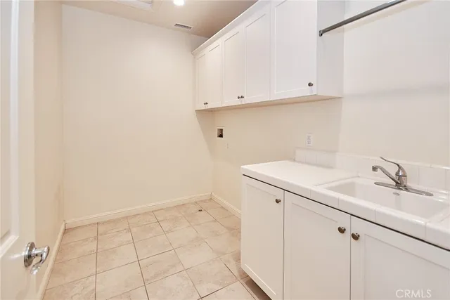 an empty room with windows and a refrigerator