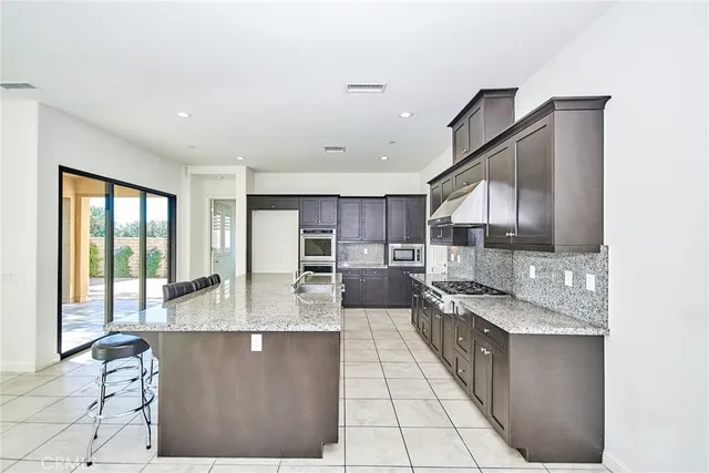 a large kitchen with kitchen island granite countertop a large window and a counter space