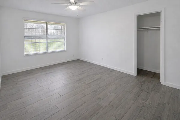 a view of a room that has wooden floor and a window