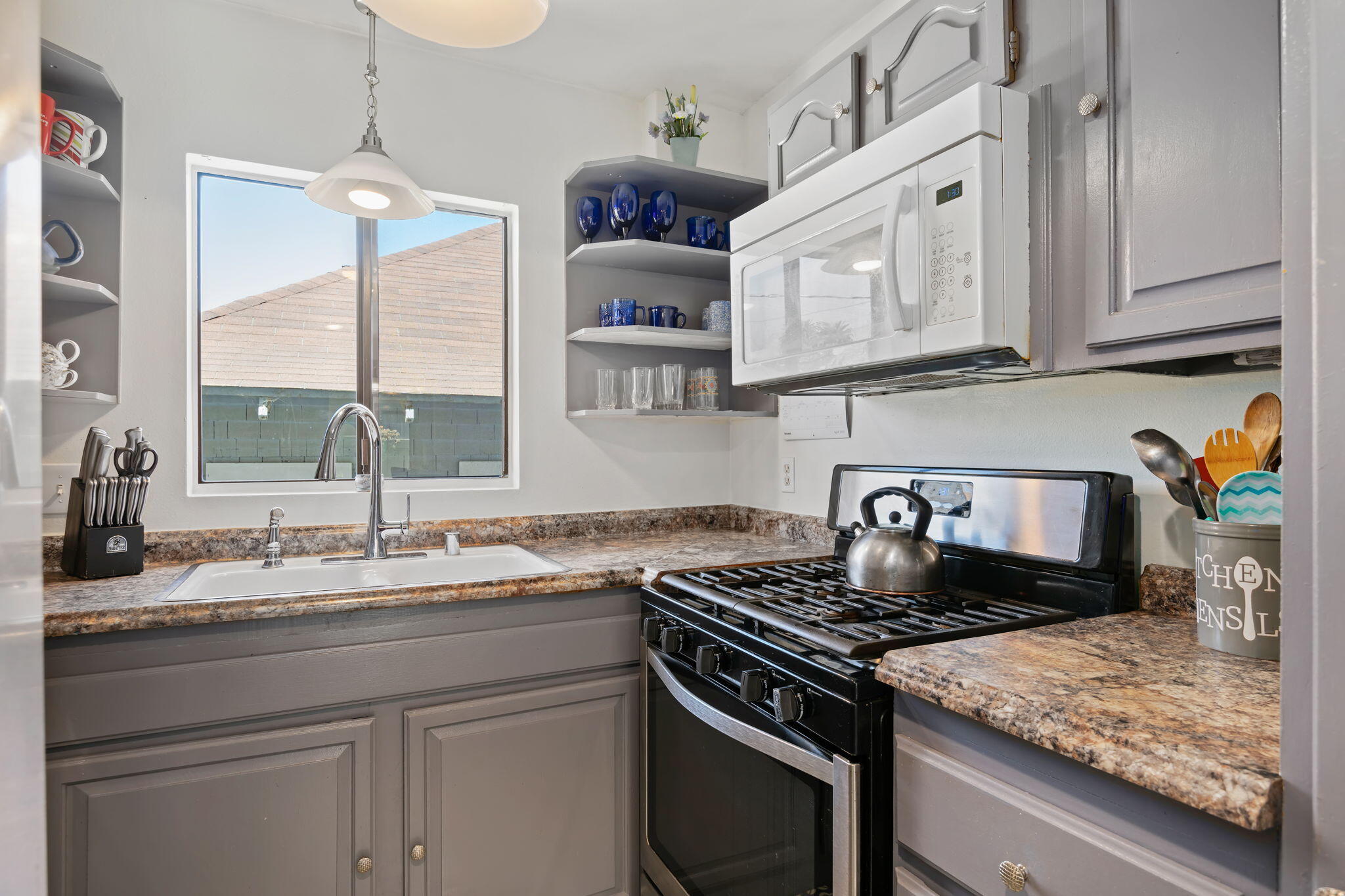 543 South E Street Oxnard, CA 93030 - Photo 10 of 30 a kitchen with stainless steel appliances granite countertop a stove a sink and a microwave