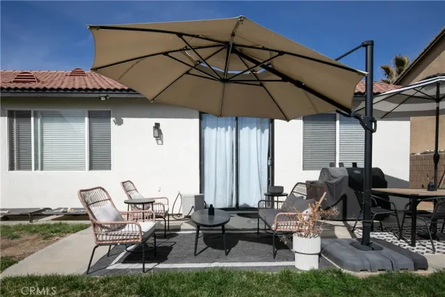 a view of a patio with table and chairs under an umbrella