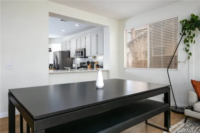 a view of kitchen island with a table chairs wooden floors and a window