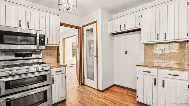 a kitchen with stainless steel appliances granite countertop a refrigerator and a stove top oven
