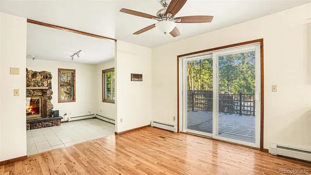 a view of an empty room with window and wooden floor