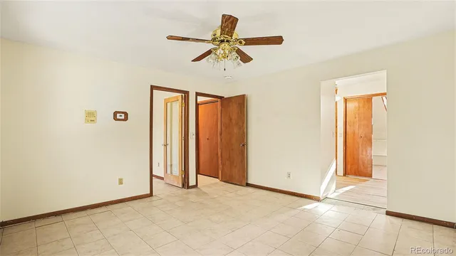 an empty room with ceiling fan and window