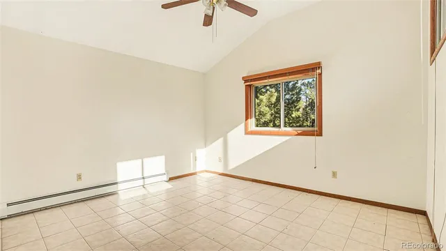 an empty room with chandelier fan and windows