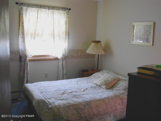 7229 Clover Road Long Pond, PA 18334 - Photo 13 of 22 a bedroom with a bed and a lamp on table