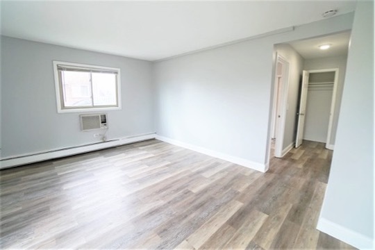 1050 North Wheeling Road, Unit 2A Mount Prospect, IL 60056 - Photo 7 of 13 an empty room with wooden floor and windows