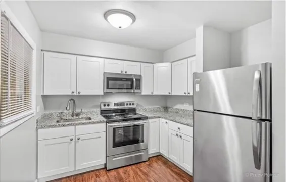 a kitchen with white cabinets and white appliances