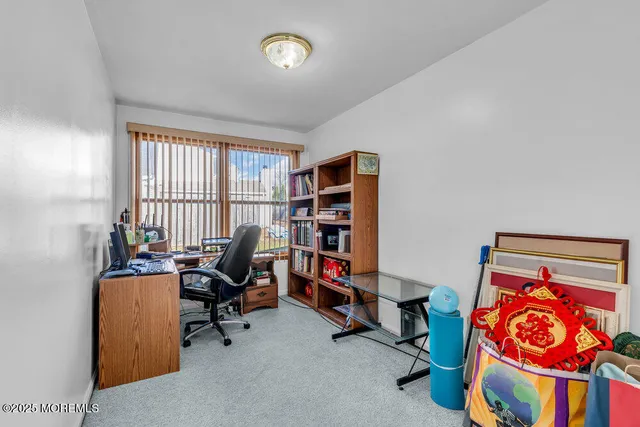 a view of a workspace with furniture and a window