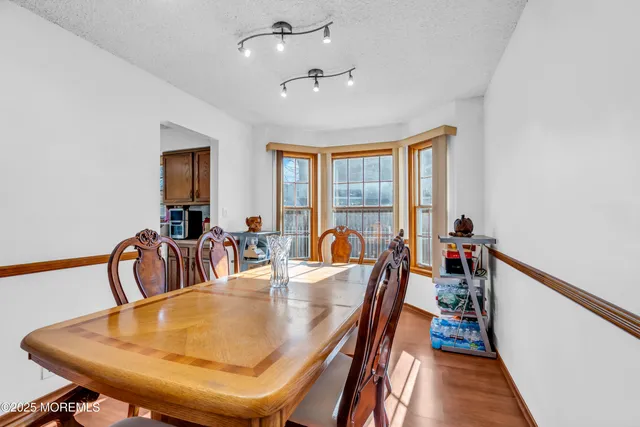a dining room with furniture a chandelier and wooden floor