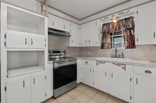 a kitchen with white cabinets stainless steel appliances and sink