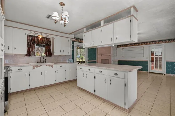 a kitchen with cabinets appliances a sink and a window