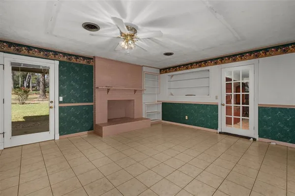 an empty room with windows and fireplace