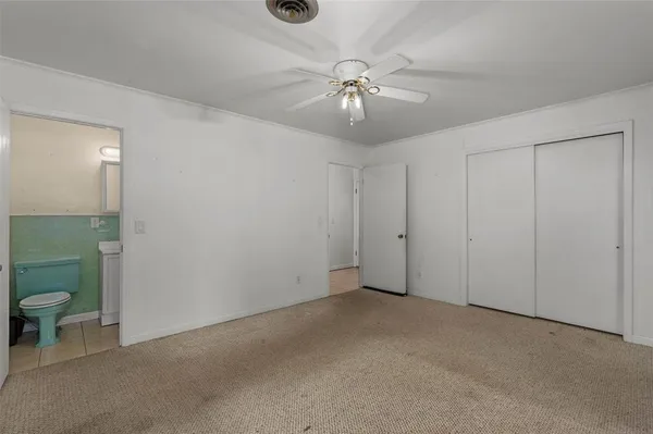 an empty room with a bathroom and a toilet