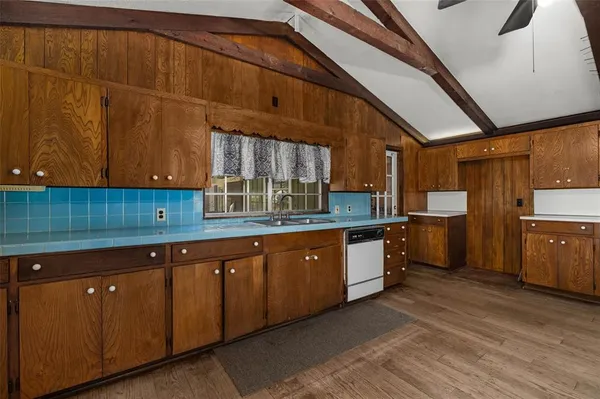 a kitchen with granite countertop wooden cabinets and white stainless steel appliances