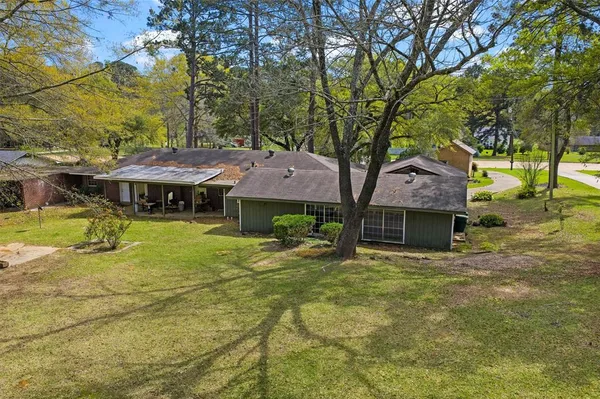 a view of a big house with pool and a big yard