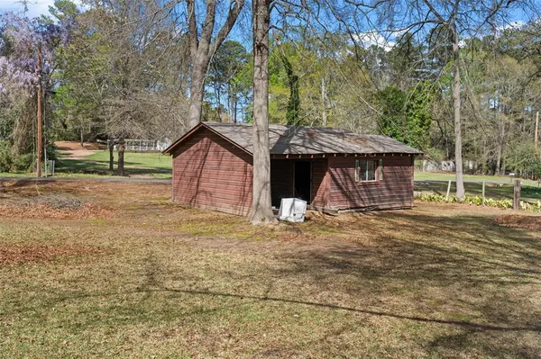 a view of a house with a yard and large tree